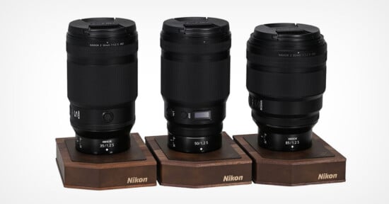 Three Nikon Z-mount lenses, labeled 35mm, 50mm, and 85mm, stand upright on individual wooden display bases against a white background.