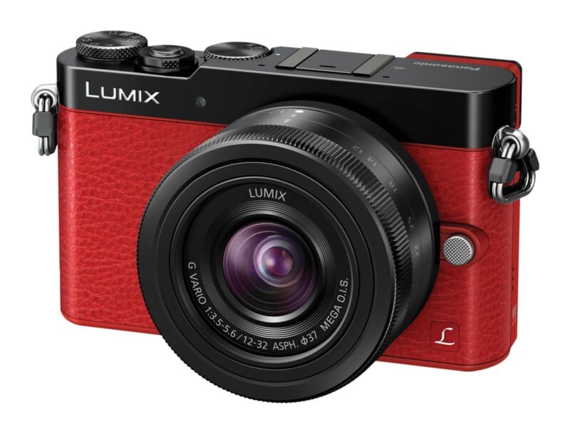 A red and black Panasonic Lumix digital camera with a 12-32mm lens attached, viewed from the front-right angle.