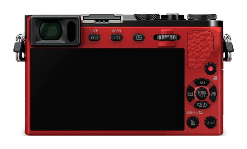 The back of a red digital camera featuring a large screen, an electronic viewfinder, various function buttons, a directional control pad, and a textured grip area.