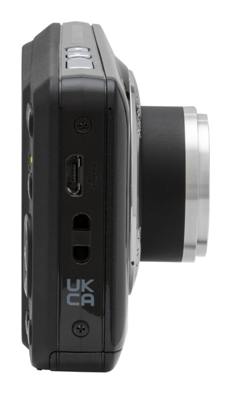 Side view of a black digital camera showing a USB port, a strap attachment point, and a UKCA marking.