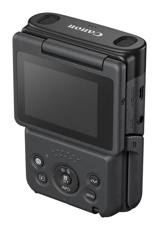 A black Canon digital camera viewed from the rear, showing a flip-out screen, control buttons, and ports for HDMI and microphone on the side.