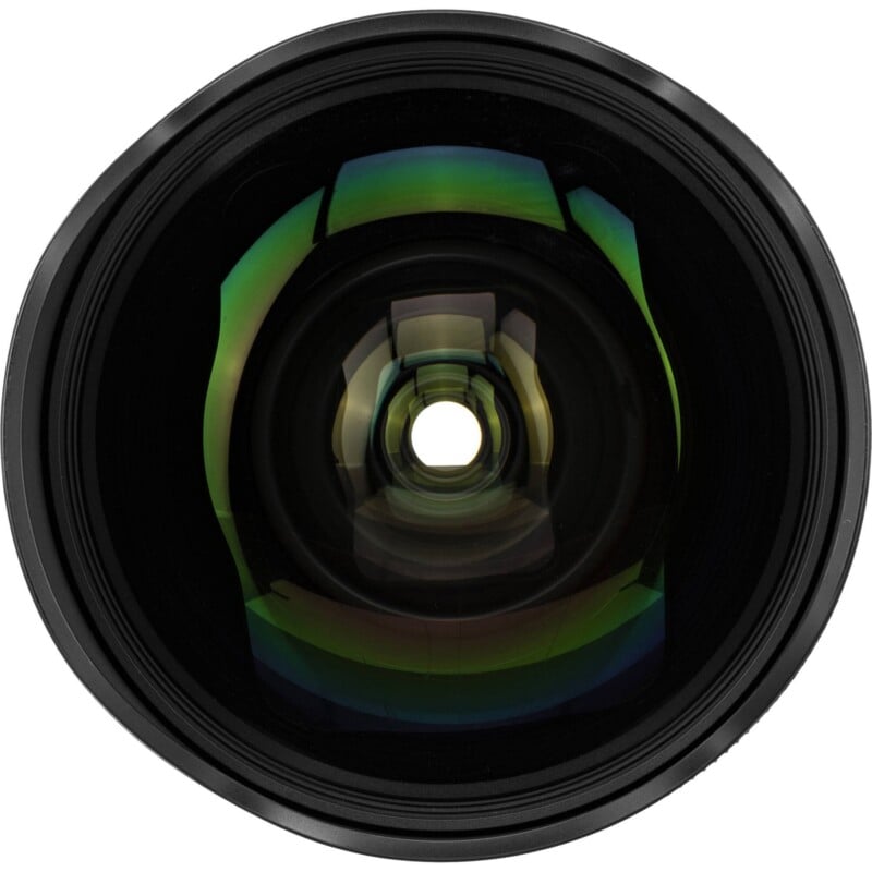A front-facing view of a camera lens showing the circular glass element with green and purple anti-reflective coatings.