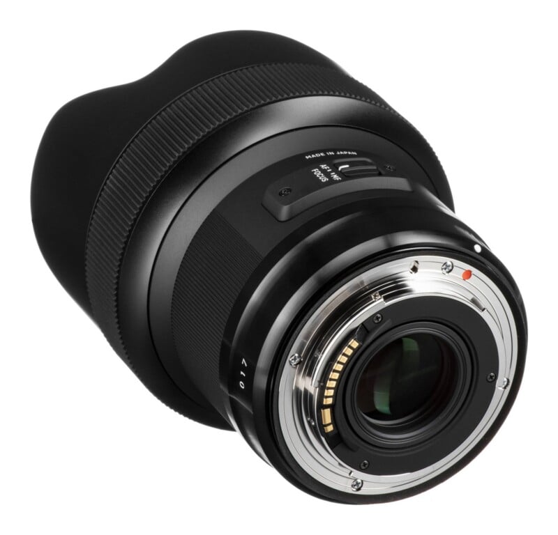 A black camera lens viewed from the rear, showing the metal mount, electronic contact pins, and an AF/MF focus switch.