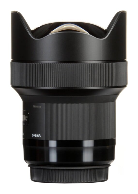 A black Sigma camera lens with a prominent, bulbous front element and a built-in petal-shaped lens hood, shown against a white background.