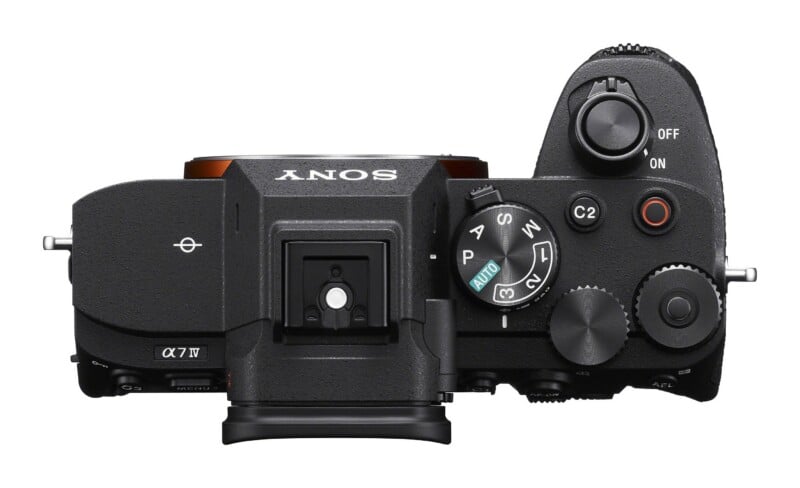 Top-down view of a black Sony Alpha 7 IV mirrorless camera body showing the mode dial, shutter button, and various control buttons.