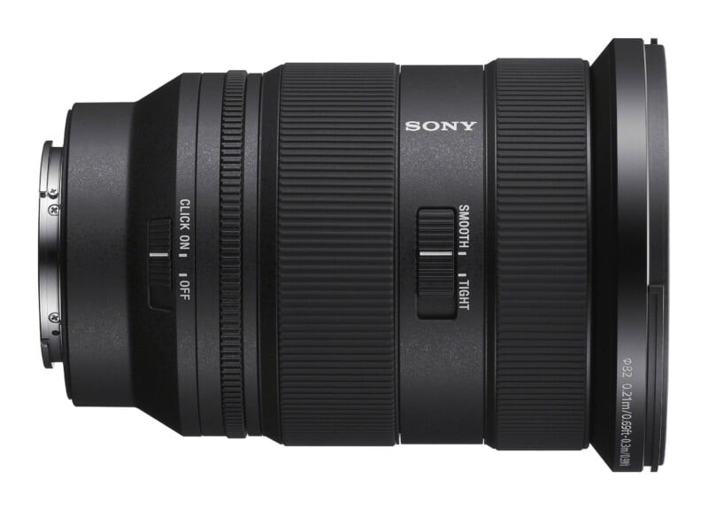 A side view of a black Sony camera lens featuring a zoom ring, a focus ring, a click switch, and a zoom smoothness switch.