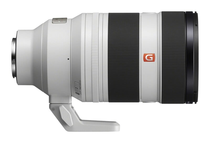 A white telephoto camera lens with black rubber grip rings and a tripod mount foot, viewed from the side against a white background.
