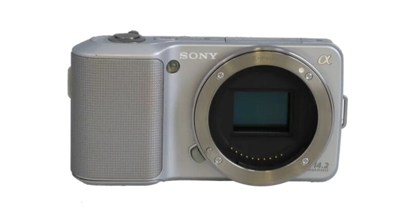 A silver Sony Alpha mirrorless camera body with an E-mount lens opening and a 14.2 megapixel label on the front.