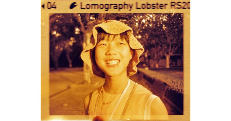 A young person with a bright smile wears a crocheted bucket hat in a warm-toned, vintage-style photograph.