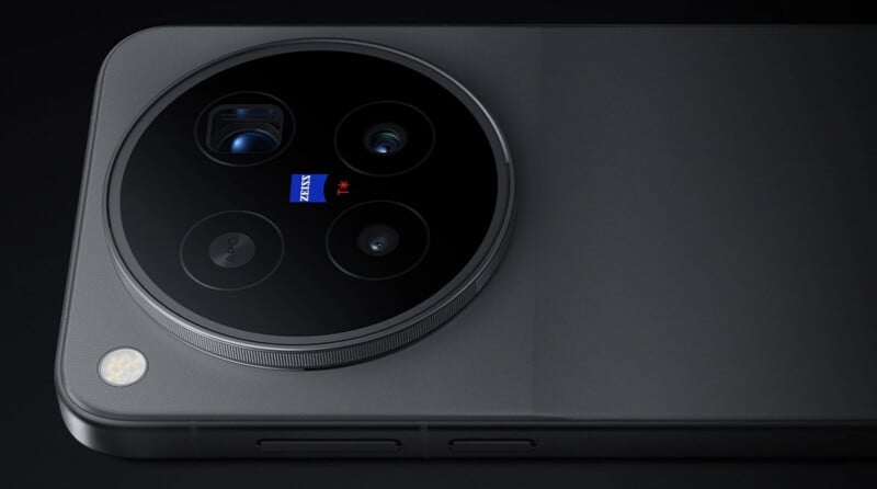 A close-up of a dark gray smartphone back featuring a large circular camera module with four lenses, a ZEISS logo, and a flash.