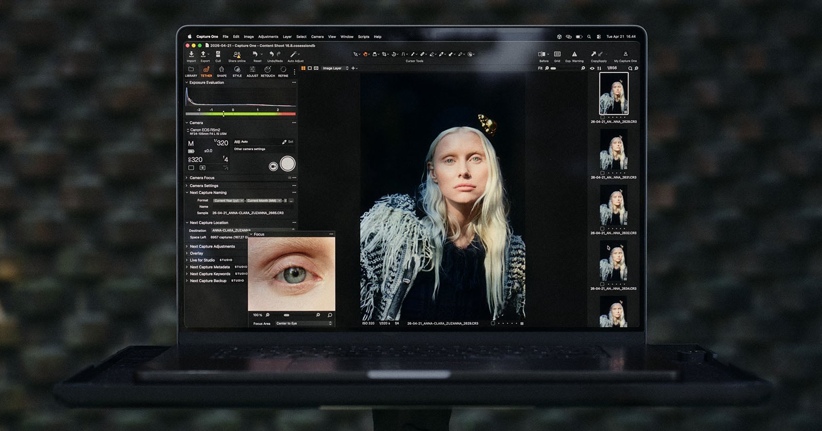 A laptop screen displays the Capture One software interface, showing a portrait of a blonde woman and a close-up focus tool of her eye.