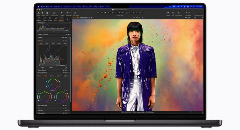 A laptop screen displays the Capture One photo editing software, showing a portrait of a person in a purple coat against a colorful, smoky background.