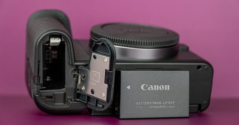 A Canon LP-E17 battery pack sits next to the open battery compartment of a black digital camera body against a purple background.