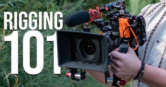 A person holds a professional cinema camera rig equipped with a matte box, a shotgun microphone, and an external monitor, with the text "RIGGING 101" overlaid on the left.