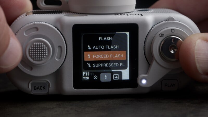A close-up view of the back of a digital camera showing a menu screen with "FLASH" settings, including "AUTO FLASH," "FORCED FLASH," and "SUPPRESSED FL.