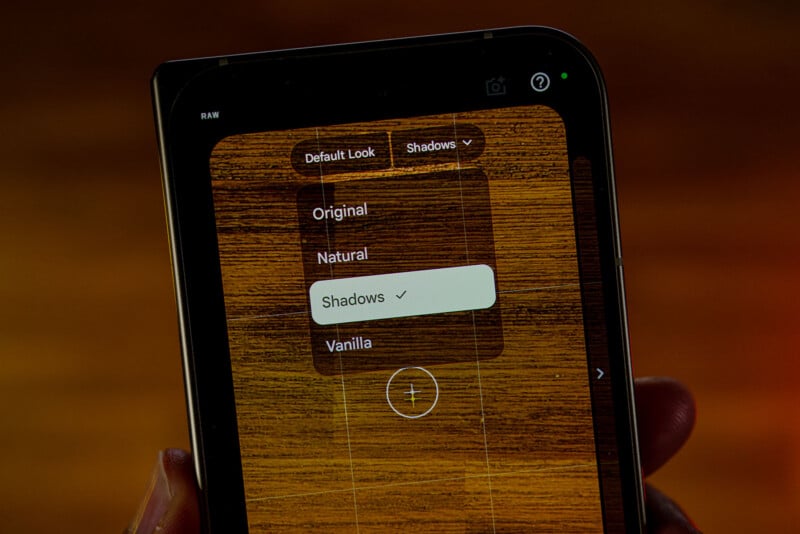 A smartphone screen displays a photo editing interface with a dropdown menu showing options for Original, Natural, Shadows, and Vanilla, with Shadows currently selected.