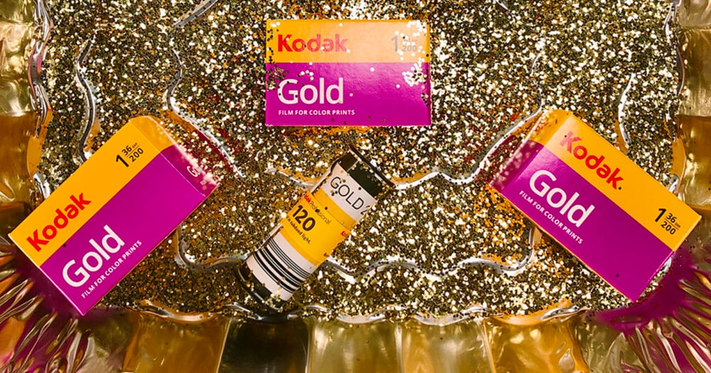 Two boxes of Kodak Gold 200 film and one roll of 120 film sit on a bed of gold glitter.
