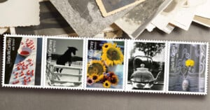A horizontal strip of five Linda McCartney commemorative postage stamps featuring her photography, resting on a surface with scattered vintage photographs.