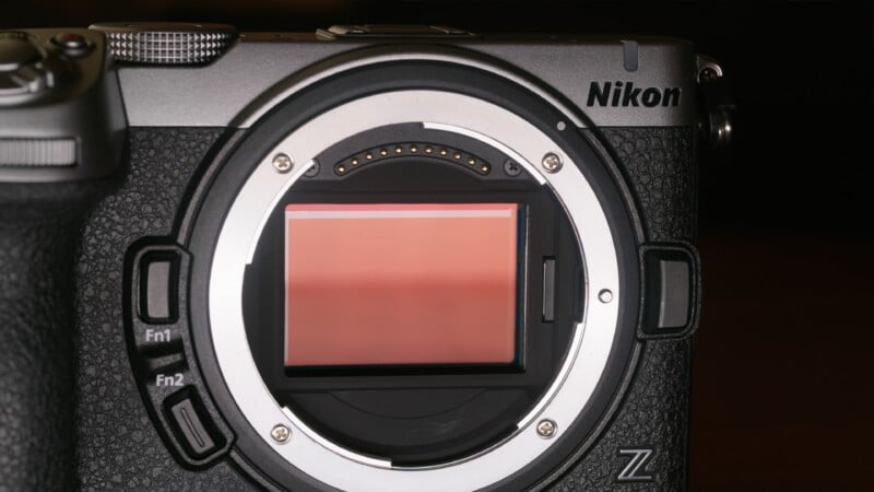 A close-up view of a Nikon Z-mount camera body with the lens removed, showing the exposed image sensor and electronic contact pins.