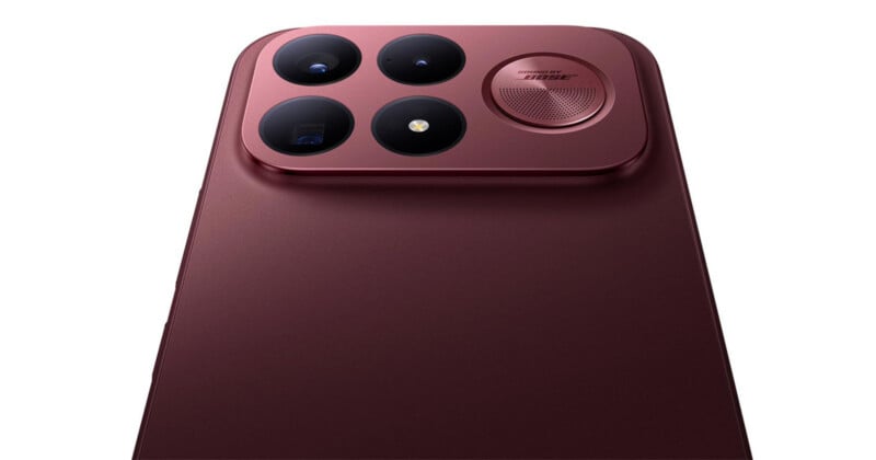 A close-up of the back of a dark red smartphone featuring a square camera module with three lenses, a flash, and a circular speaker grille labeled "SOUND BY BOSE.