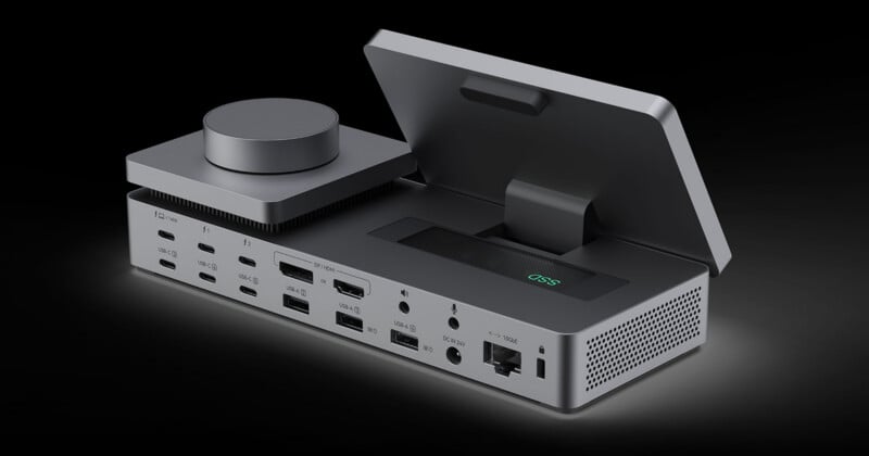 A gray, multi-port docking station with a circular dial on the left, an open storage compartment labeled "SSD" on the right, and various USB, display, audio, and network ports along the back.
