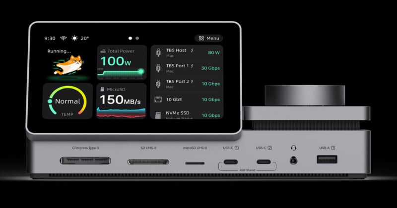 A silver docking station with a built-in touchscreen display showing system performance metrics, featuring various ports including card readers, USB-C, and USB-A.