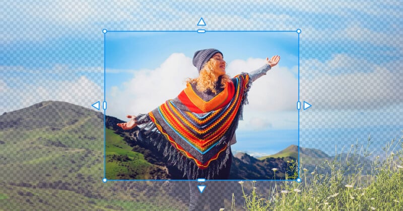 A woman with curly blonde hair wearing a beanie and a colorful, fringed poncho stands with her arms outstretched against a mountainous landscape, framed by a digital selection box.
