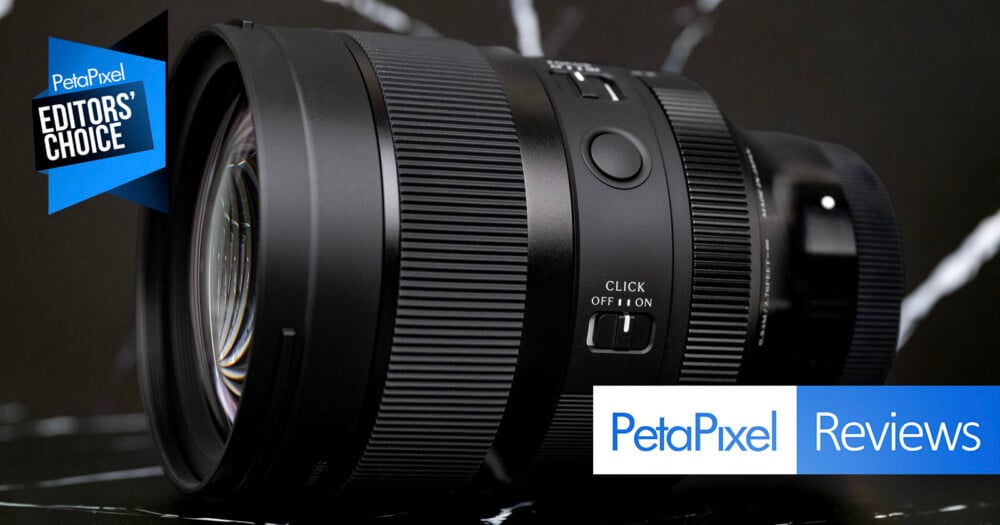 A black camera lens sits on a dark, marble-patterned surface, featuring a "CLICK OFF/ON" switch and a "PetaPixel EDITORS' CHOICE" award badge in the upper left corner.