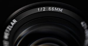 A close-up view of a camera lens barrel showing the text "f/2 66MM" and a partial view of the word "WETZLAR".