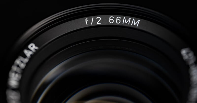 A close-up view of a camera lens barrel showing the text "f/2 66MM" and a partial view of the word "WETZLAR".