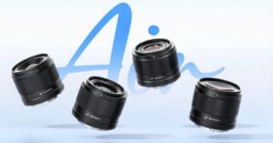 Four camera lenses float against a light blue background with the word "Air" written in large, stylized blue script behind them.