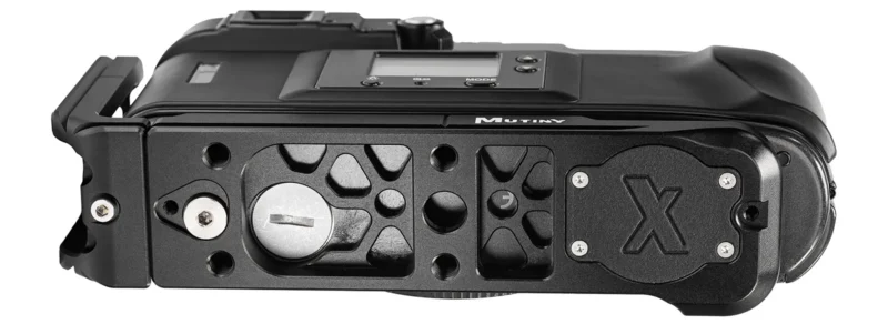 The underside of a black camera body featuring a metal baseplate with the word "MUTINY" and a large "X" logo engraved on a plate.