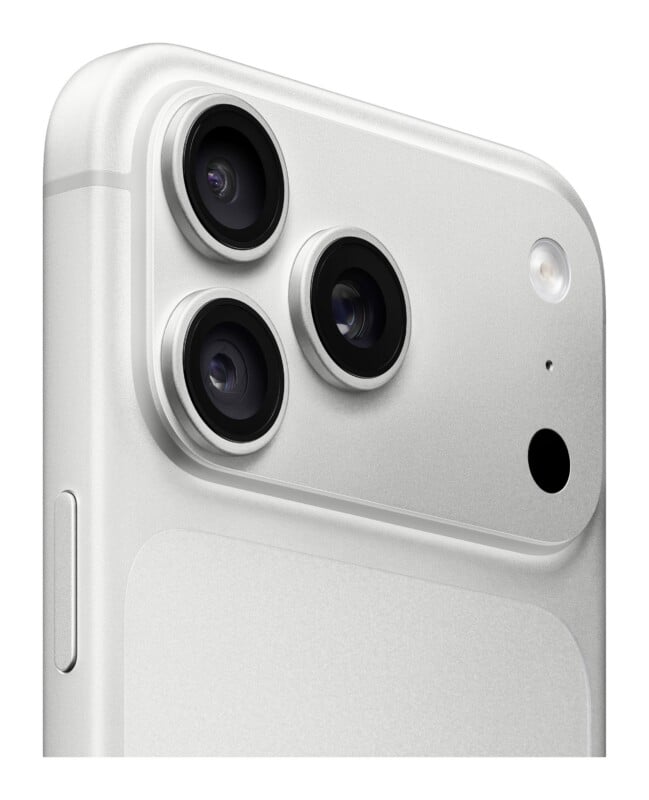 A close-up, angled view of a silver smartphone back featuring a triple-lens camera array, a flash, and a small sensor.