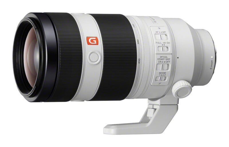 A white Sony G Master telephoto zoom lens with a black focus ring, tripod mount, and various control switches on the side.