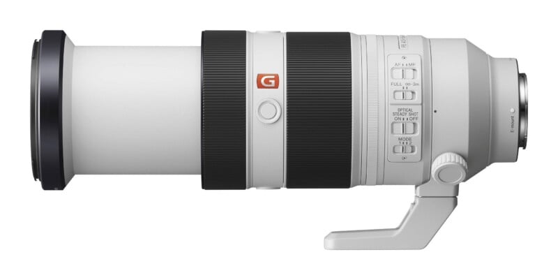 A white telephoto zoom lens for a camera with a black front element, two black rubber grip rings, and a series of switches on the side.