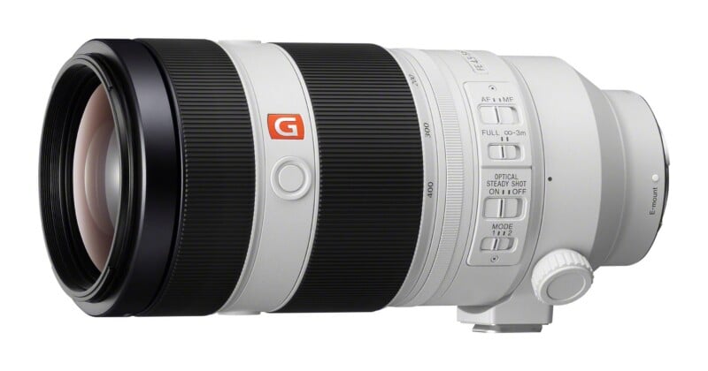 A white telephoto camera lens with black rubber zoom and focus rings, featuring a G-Master logo and various control switches on the side.
