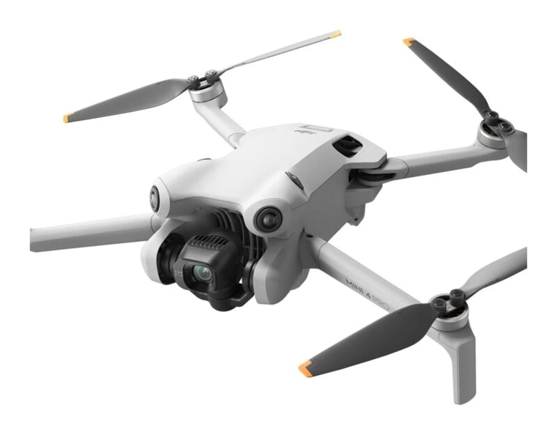 A white DJI Mini 4 Pro drone with four propellers and a front-facing camera gimbal, shown against a white background.