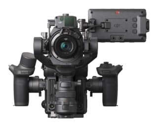 A professional cinema camera rig with a gimbal-mounted lens, two side handgrips, and a side-mounted monitor screen.
