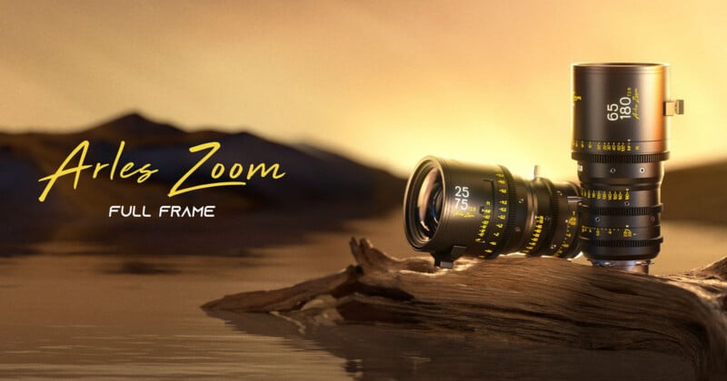 Two Arles Zoom full-frame cinema lenses rest on a piece of driftwood against a sunset background.