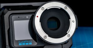 A close-up view of a GoPro camera body featuring a large, circular lens mount adapter with a visible red alignment dot and a rectangular sensor in the center.