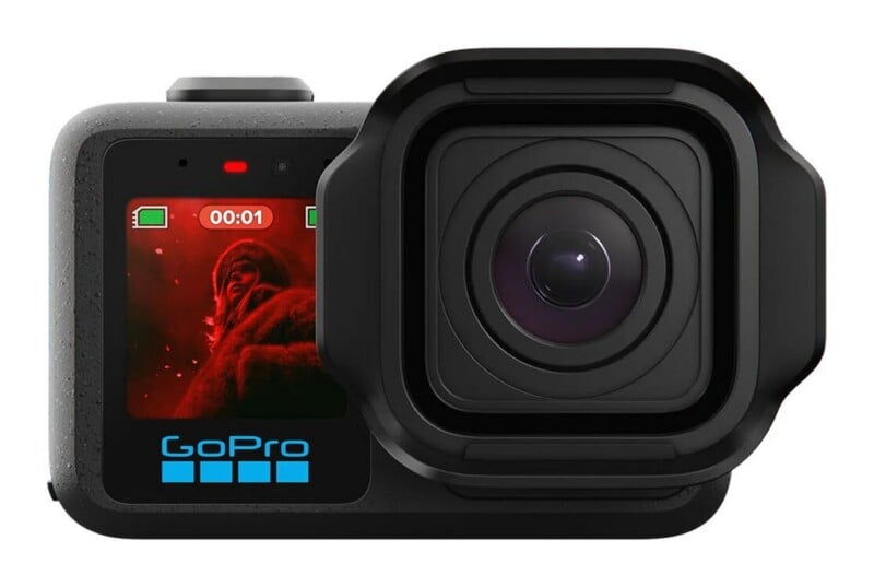 A black GoPro action camera with a front-facing color display showing a recording timer and a person, with the lens housing positioned to the right.