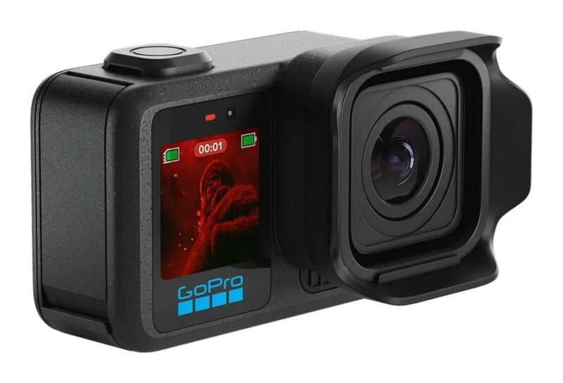 A black GoPro action camera with a front-facing screen displaying a red-toned image and a protective lens hood attached.