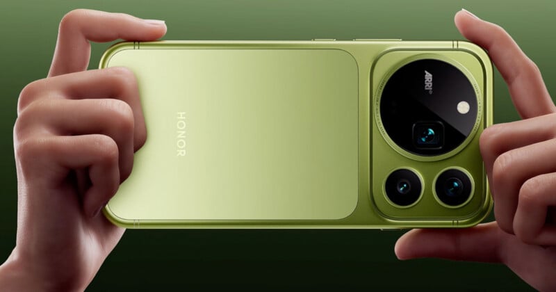 A pair of hands holds a light green Honor smartphone horizontally against a matching green background, highlighting the prominent circular camera module on the back.