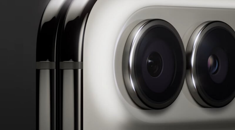 A close-up view of two circular camera lenses set into a metallic, light-colored housing on the back of a smartphone.