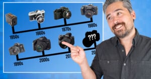 A man points to a timeline of cameras ranging from the 1950s to the 2020s, with a question mark silhouette representing the final decade.