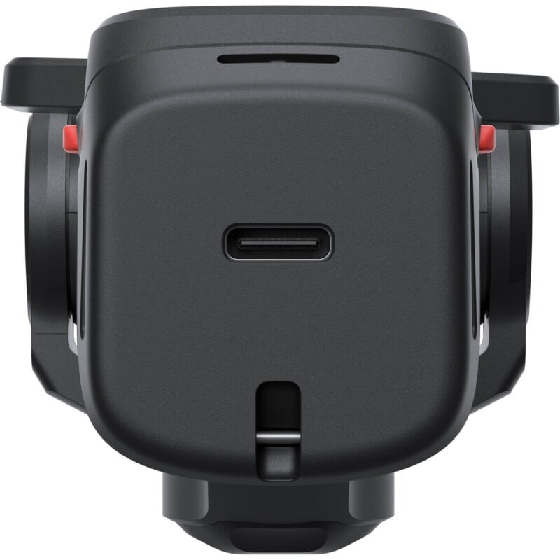 A close-up, front-facing view of a black electronic device featuring a central USB-C port, a small horizontal vent above it, and a latch mechanism at the bottom, flanked by two red-accented side components.