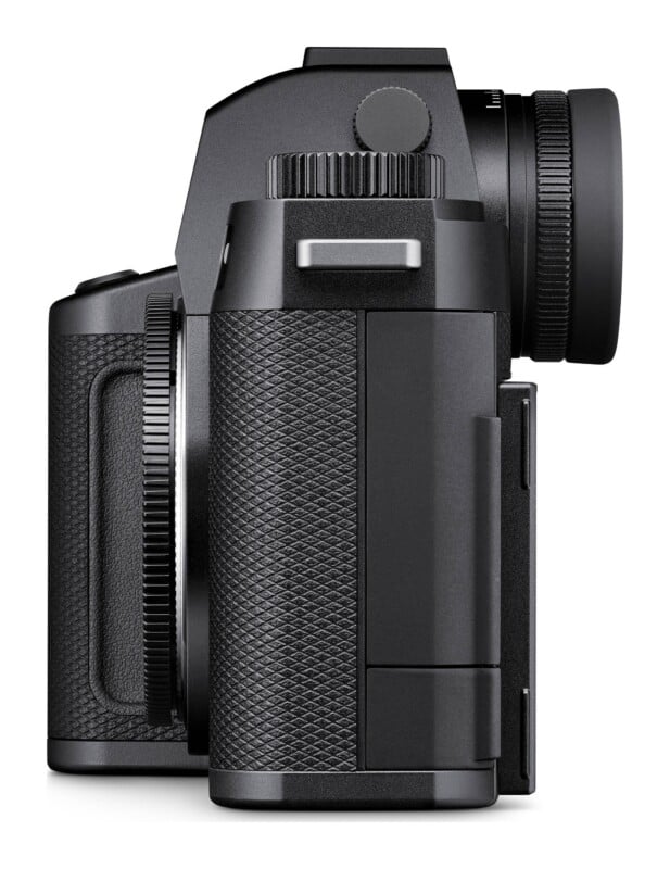 A side profile view of a black digital mirrorless camera body with a textured grip and a circular viewfinder eyepiece.