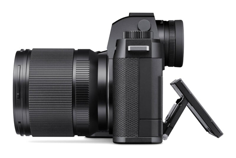 A side profile of a black mirrorless camera with a lens attached and its rear LCD screen tilted outward.