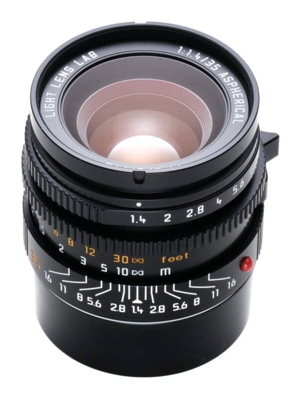 A black camera lens with a focus ring, aperture ring, and depth of field scale, labeled "Light Lens Lab 1:1.4/35 Aspherical.
