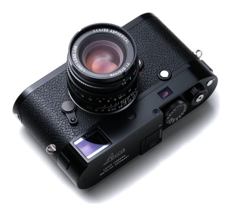 A black Leica M-P rangefinder camera with a 35mm f/1.4 lens attached, viewed from a high angle against a white background.